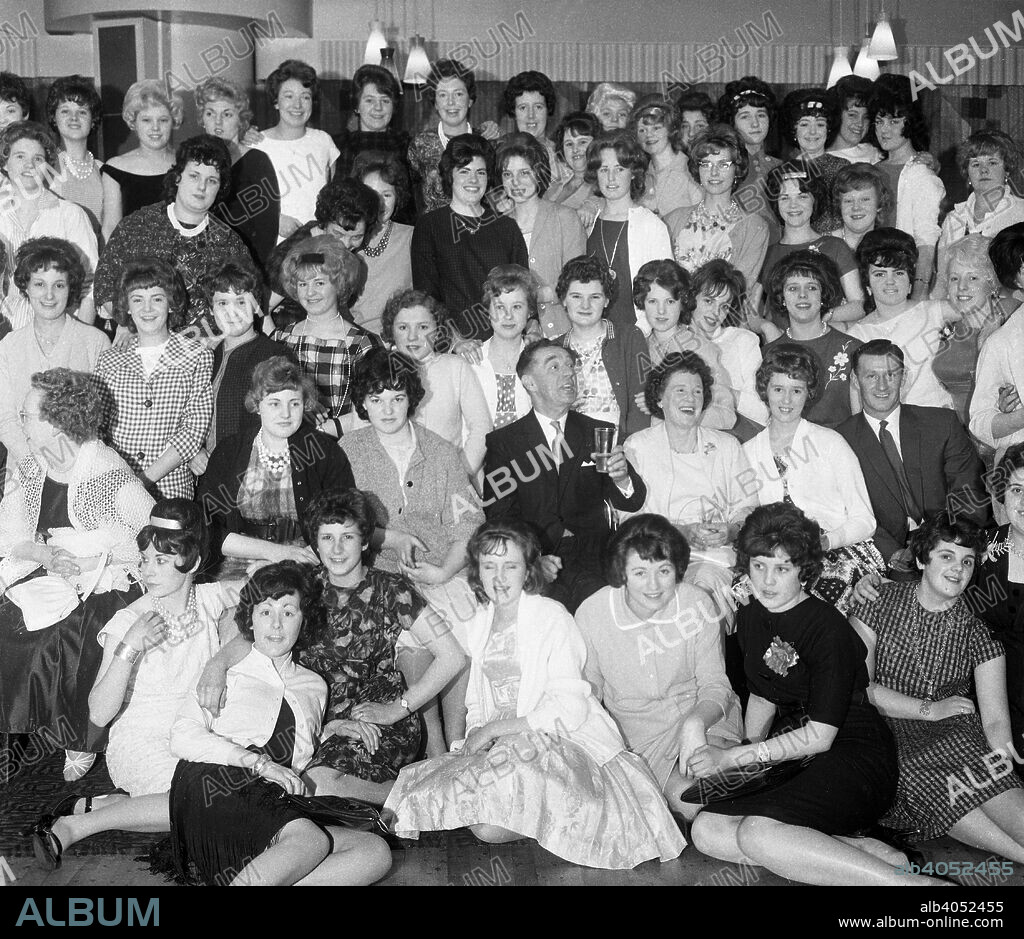 Women from the ICI Doncaster plant at a social gathering, South Yorkshire 1962. A group of women from the ICI fabrics plant in Doncaster gather for a group photograph at a social gathering in the town. It is assumed the two men present are management, who are looking a little outnumbered.