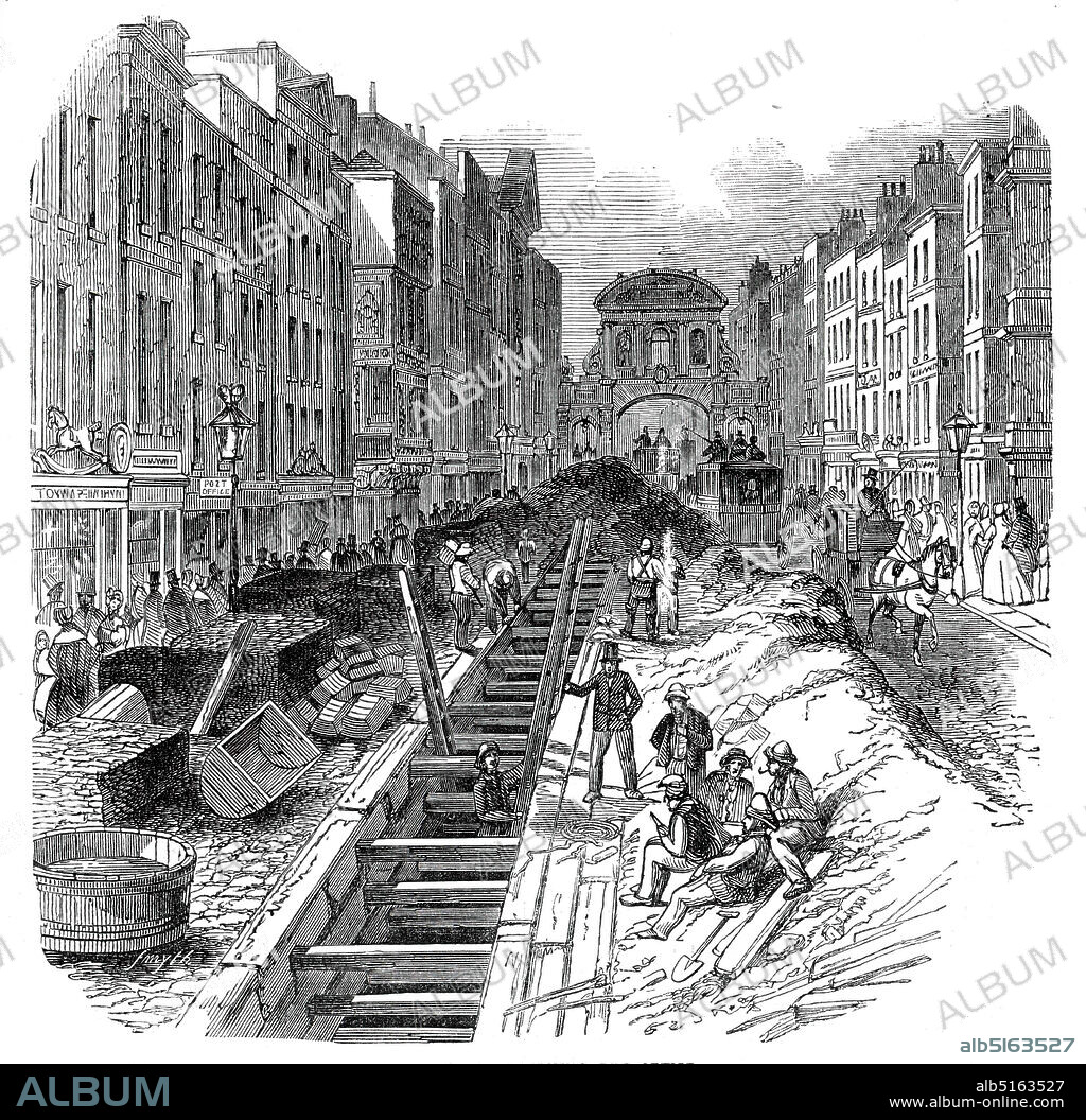 Fleet-Street, deepening the sewer, 1845. Workers improving the underground waste system in London, with Temple Bar in the distance. '...the difficulty of keeping open the traffic, so as not to extinguish the "very animated appearance" of Fleet-street, is a work of much difficulty. The cost of the present undertaking, contracted for by Messrs. Ward and Son, of Aldersgate- street, is £2000...There do not appear to be published data from which the total extent of the metropolitan Sewers can be ascertained. The Holbom and Finsbury divisions contain eighty three miles. In addition to these, there are sixteen miles of smaller Sewers, to carry off the surface-water from the streets and roads, and two hundred and fifty-four miles of drains leading from houses to the main Sewers'. From "Illustrated London News", 1845, Vol VII.