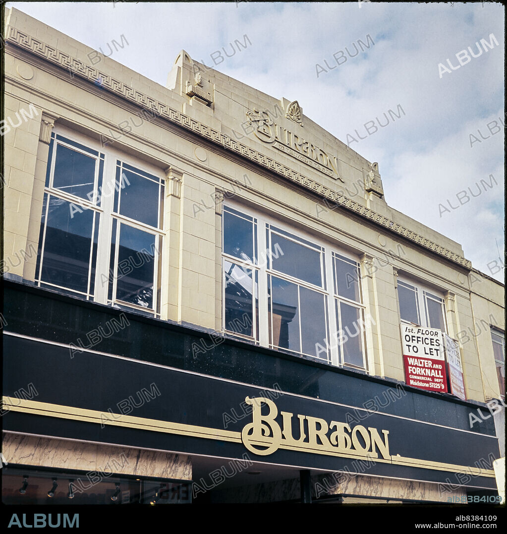 NICHOLAS ANTHONY JOHN PHILPOT. Burton, 17-19 Week Street, Maidstone, Maidstone, Kent, 1970s-1990s. Looking up at the first floor facade of the Burton store at 17-19 Week Street, showing the Burton logo carved in relief on the central parapet above. The store closed as a Burton and Dorothy Perkins at some time between 2018 and 2021.