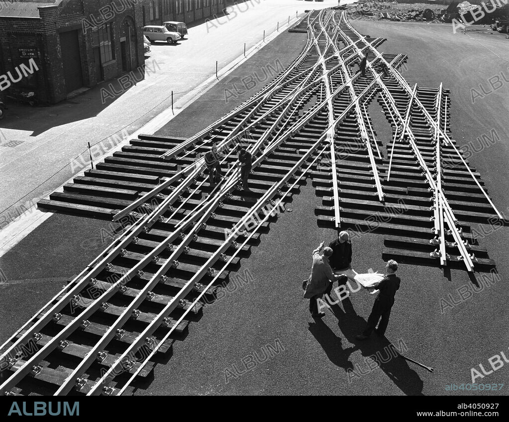 Railway track work at Edgar Allen's steel foundry, Sheffield, South Yorkshire, 1962. Like a giant train set, track work is laid out in the foundry yard with workers and management checking the technical drawings.