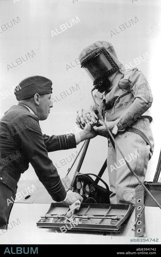 Highest in an Airplane New World's Altitude Record by British R.A.F.:
Final adjustments being made to squadron leader sealed oxygen flying suit before his record breaking ascent. The Air Ministry announced the record this evening September 29.
Squadron Leader F. R. D. Swain of the Royal Air Force made a new world's altitude record for Airplanes of 49,967 feet here today. He made the record in a Bristol Monoplane. the largest single-seater ever constructed. He wore a specially constructed sealed oxygen flying suit, in which free movement for the controls was possible. October 19, 1936. (Photo by Associated Press Photo).