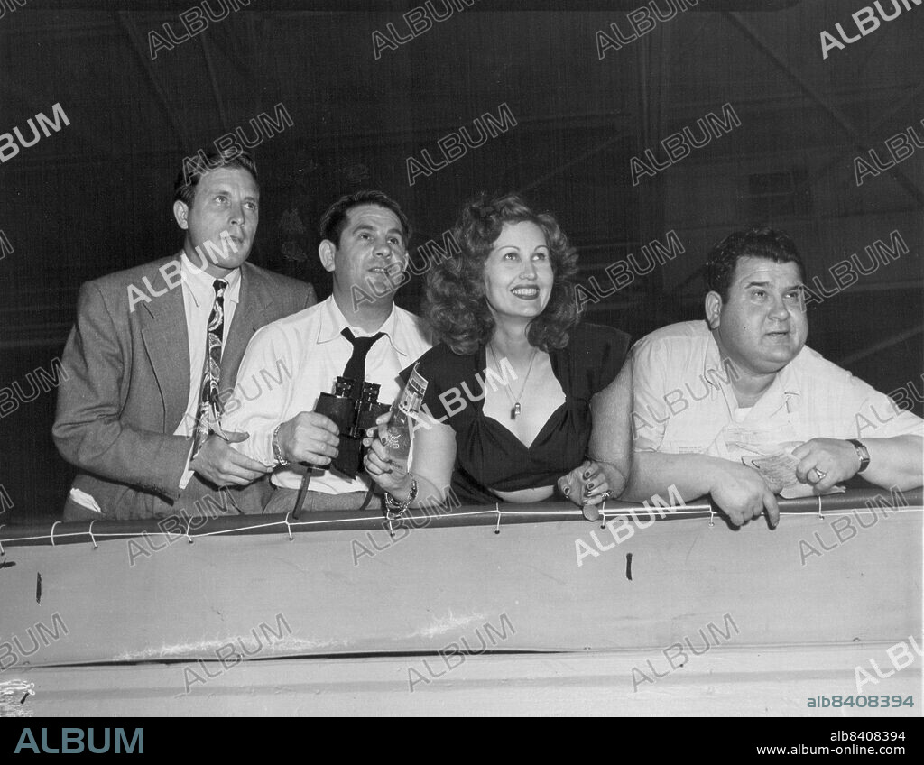 Left to right: Lawrence Tierney, Morrie King, May Mann, film magazine writer and Frank King. The King brothers, film producers noted for ability to operate on small budget," discovered" Tierney and made him famous in their production of "Dillinger."After his first film as gangster John Dilklinger, Tierney was at Santa Anita races in 1945 with producer Morrie King and writer May mann. June 25, 1945.