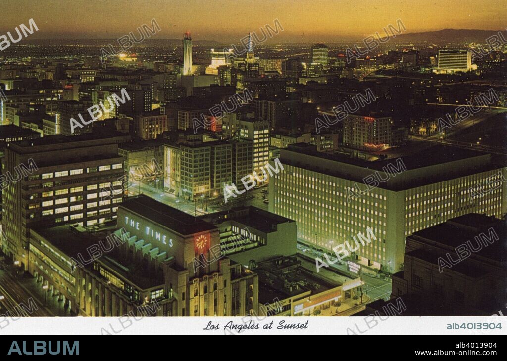Sunset, Los Angeles, California, USA, 1970. Vintage postcard showing a bird's eye view of Los Angeles at sunset looking south-west from the City Hall tower. The Art Deco Los Angeles Times Building, built in the 1930s, is in the foreground.