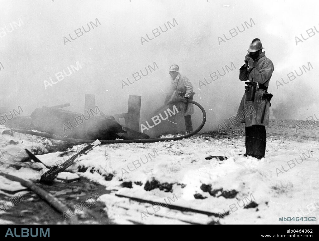 Göteborg 1937-01-18 - Två brandmän släcker en brand . - det är fabriken Treco som brinner - madrass och trasselfabriken i Majorna - . *** Local Caption *** GT Låda 1937-jan-02. KAMERAREPORTAGE.