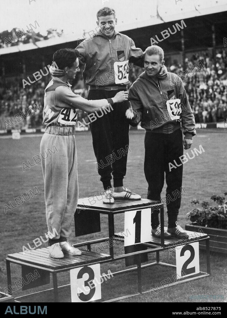 ARKIV STOCKHOLM 19580820.. Peter Radford (t.v.), Storbritannien, gratulerar Armin Hary, Tyskland, och Manfred Germar, Tyskland, efter deras dubbelseger på 100 m under friidrotts-EM på Stockholms stadion.. Foto: SVT / Kod: 5600. AB Text & Bilder. Mapp: Em i fri idrott 1958: Div. grenar . Vänner Leende Siffror Prispallar Prisutdelningar Vinnare Segrare Trio.