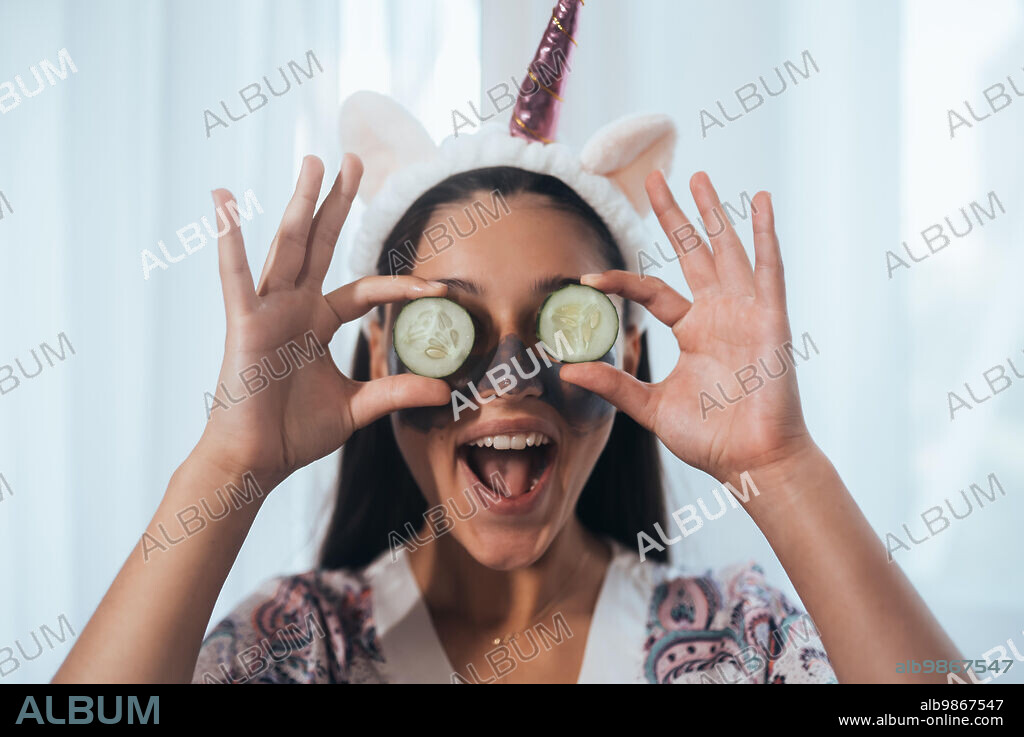 Funny smiling Spa Woman with fresh Facial Mask hold cucumbers. Beautiful Woman Applying Natural Homemade Facial Mask || Model released. 28/07/2022