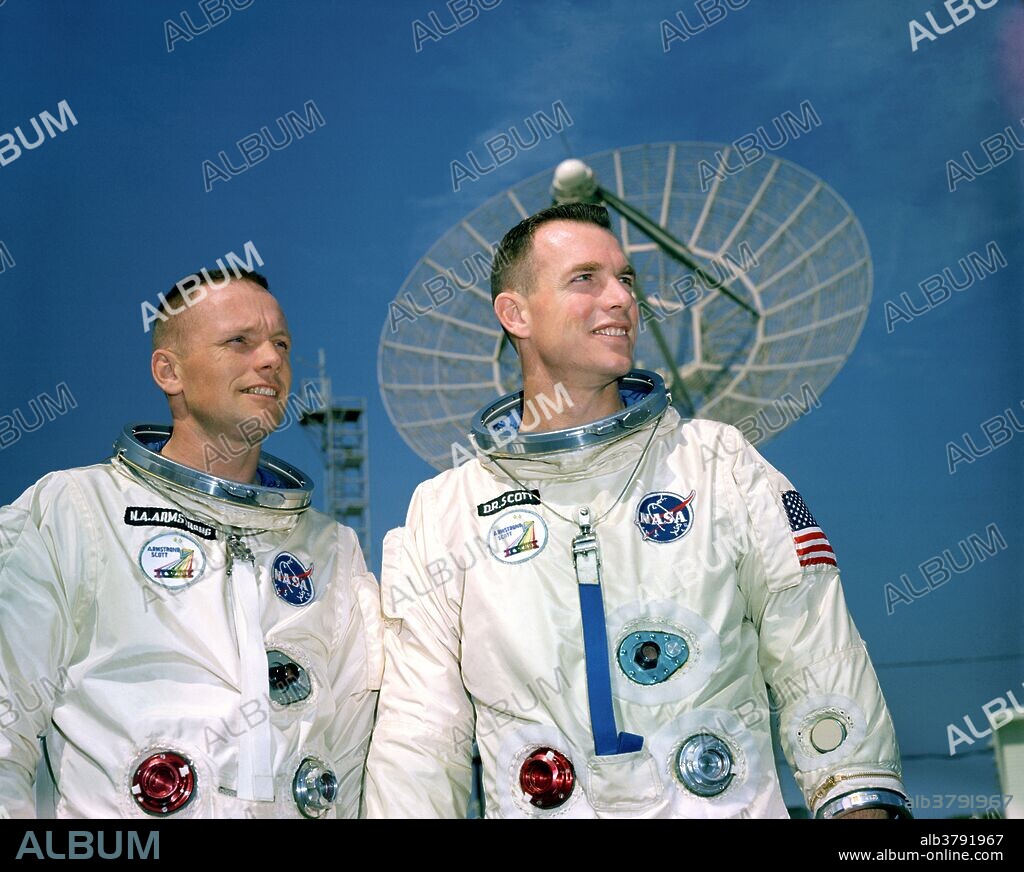 Astronauts Neil A. Armstrong left, command pilot, and David R. Scott, pilot, the Gemini 8 prime crew, during a photo session outside the Kennedy Space Center KSC Mission Control Center. They are standing in front of a radar dish.