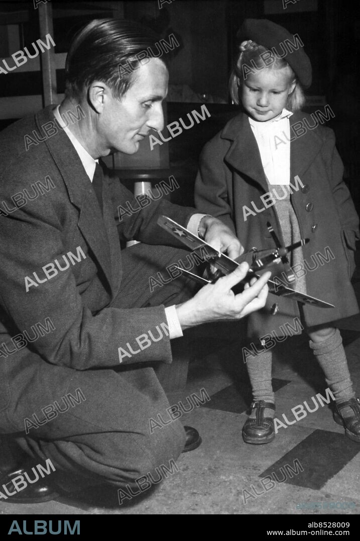 ARKIV STOCKHOLM 19490531.. Abessinienflygaren greve Carl Gustaf von Rosen demonstrerar ett miniatyrflygplan för sin dotter Astrid vid ett besök på Ostermans Bilhallar.. Foto: Tore Ekholm / AB Text & Bilder / SVT / Kod: 5600. Mapp: Rosen, Carl Gustaf von. Modeller Profiler Baskrar.