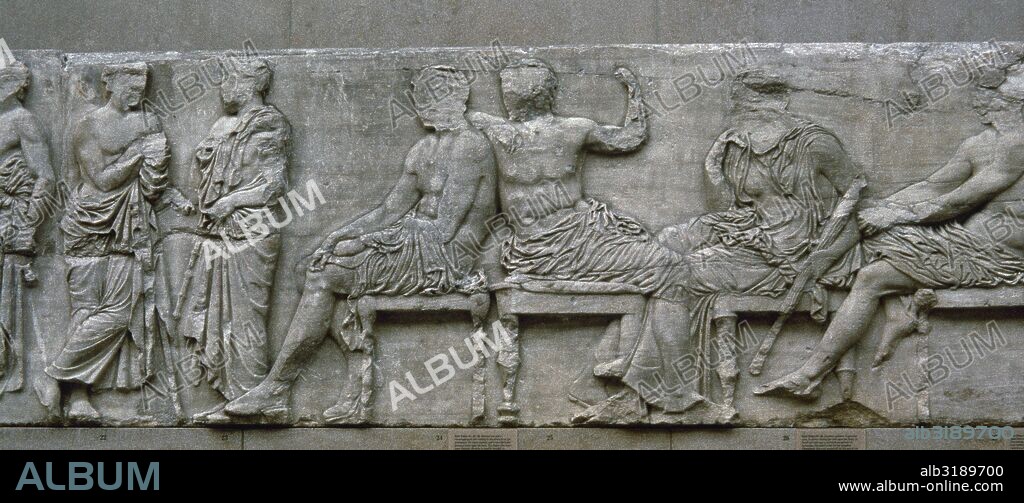 The East frieze of the Parthenon, Acropolis of Athens, Greece. Sacrificial procession. Gods and Godesses. The Peplos Scene. Pentelic marble. Stone number I IV, figures E 21-23 (male figures), E 24 (Hermes) E 25 (Dionysos), E 26  (Demeter) E 27 (stalwart god). British Museum. London, United Kingdom.