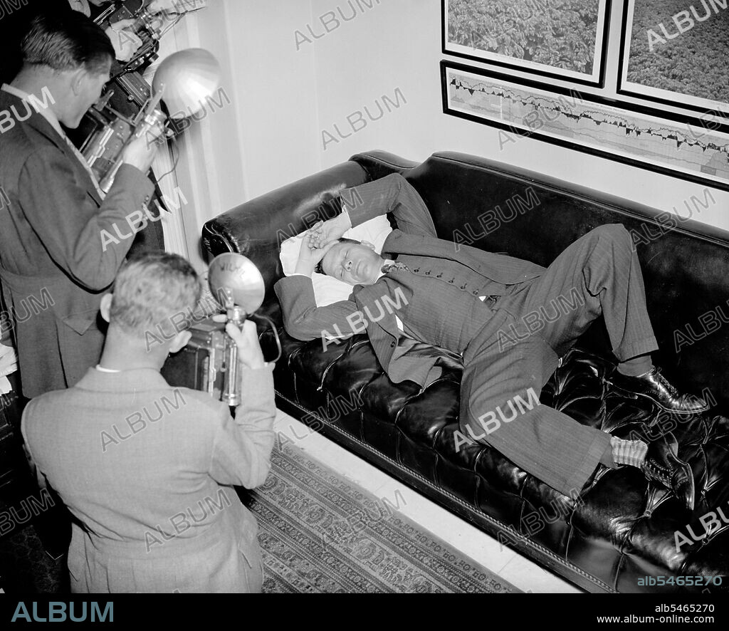 Senator Allen Ellender Democrat of Louisana and onetime Lieutenant of the late Huey Long, is snapped by news cameramen as he rests in his office  circa 1938.