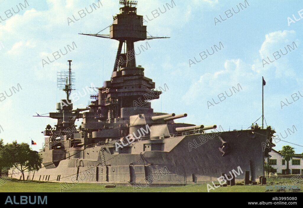 The battleship USS 'Texas', San Jacinto Battlegrounds, near Houston, Texas, USA, 1958. Vintage postcard. Commissioned in 1914, the USS 'Texas' saw action in both World Wars. Since 1947 she has been preserved as a museum ship in the Houston Ship Channel near the San Jacinto Memorial, which can be seen in the background.