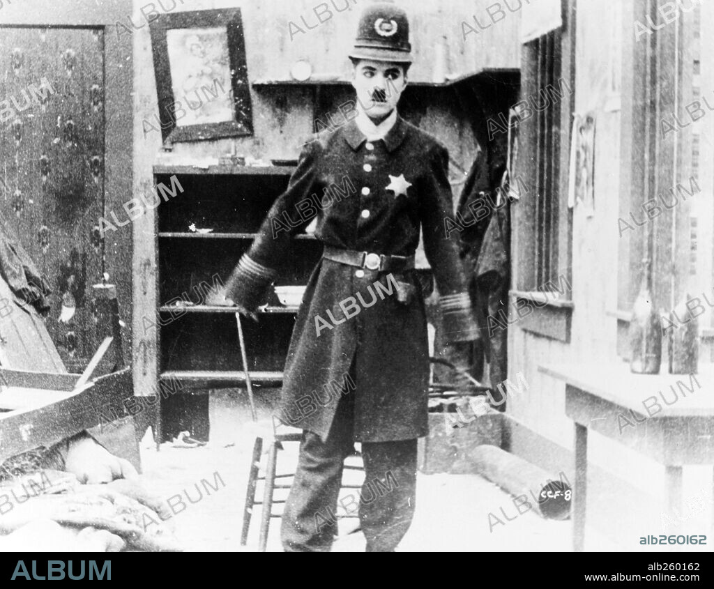 CHARLIE CHAPLIN en CHARLOT EN LA CALLE DE LA PAZ, 1917 (EASY STREET), dirigida por CHARLES CHAPLIN. Copyright MUTUAL FILM COMPANY.