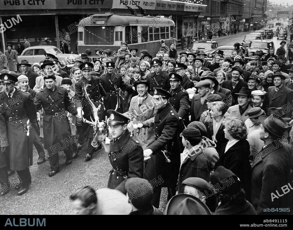 STOCKHOLM 1957-12-01.. ALLA MOT ALLA. Frågelek i radion.. Sänt under säsongen 1958.. Här ses polisen komma programledaren Lennart Hyland till hjälp, då han genom stadens gator för sin ren, en gåva från Kiruna, till Skansen.. Foto: Jarl Ekenryd / RiR / SVT / Kod: 5600. RiR 14167 sv/v. Mapp: Hyland, Lennart Radio Alla mot alla L 14. Renar.
