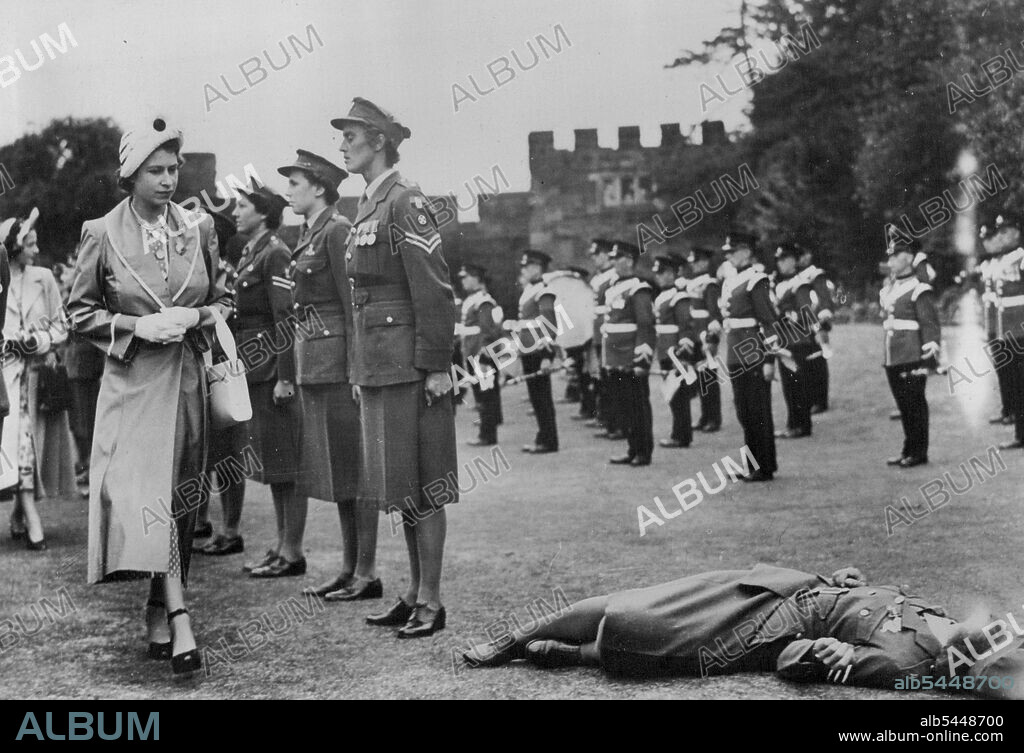 Girl Sergeant Faints At The Feet Of The Princess - With Guard-like discipline, these members of the Women's Royal Army Corps stand rigidly to attention ***** Sergeant Jean Bayliss faints - and Princess Elizabeth looks on sympathetically, and continues her inspection of the Guard of Honour at Shrewsbury Castle here, before going on to the Royal Agricultural Show. After the parade, the Sergeant was carried off. July 7, 1949.