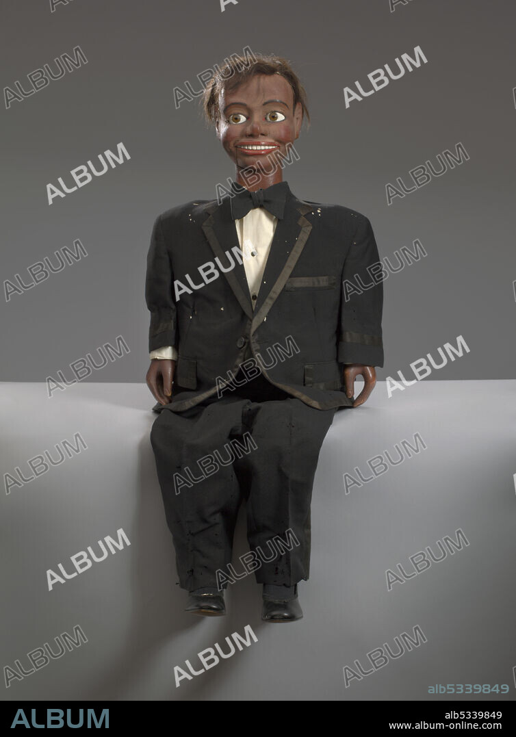 Ventriloquist's dummy owned by African-American actor and stand-up and TV comedian Stewart Byron "Stu" Gilliam (1933-2013). A male ventriloquist doll made of wood. The doll, named Oscar Land, is painted brown and has pink accents to highlight the nose, cheeks, and lips. The doll has brown eyes, black hair and is wearing a black and white tuxedo and black shoes.