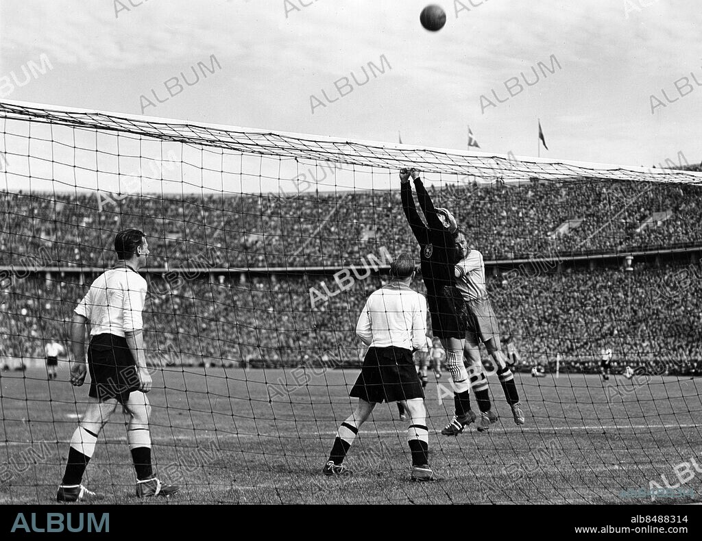 TYSKLAND BERLIN 1942-09-20.. Sverige möter Tyskland i en fotbollslandskamp på Olympiastadion i Berlin som Sverige vann med 3-2. Här ses den tyske målvakten Jahn rädda en hörnboll. Här ses den svenske spelaren Gunnar Gren bakom målvakten och tv ses de tyska spelarna Sold och Müller.. Foto: AB Text & Bilder / SVT / Kod: 5600. Tysk originalbildtext.. Mapp: Fotbollandskampen Sverige-Tyskland i Olympiastadion i Berlin 20 espt. 1942. (3-2!) I:8 1/2A. Matchbilder.