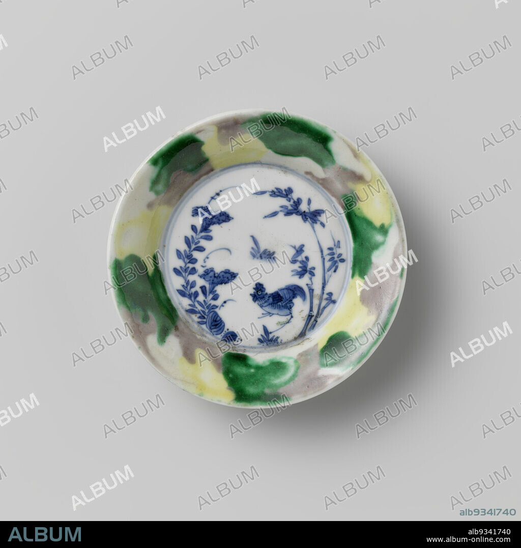 Saucer with 'egg and spinach' pattern and cock among plants, Deep dish of porcelain, painted in underglaze blue and on the glaze green, yellow and eggplant. On the plate a cock next to bamboo and a flowering plant; the wall covered inside and out with an 'egg and spinach' pattern. Marked on the bottom with a mushroom (lingzhi). Famille verte., anonymous, China, c. 1700 - c. 1720, porcelain, glaze, painting, vitrification, height 2.1 cm, diameter 10 cm, diameter 5.4 cm.