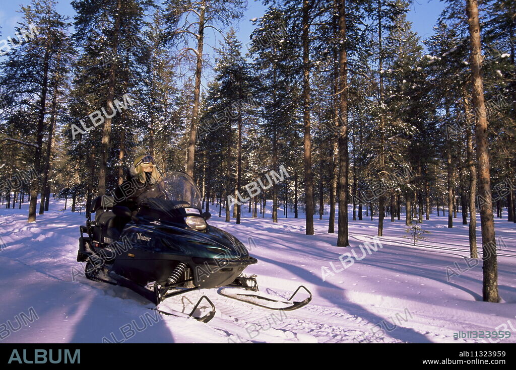 Woman driving snowmobile near Lulea, Lapland, Sweden, Scandinavia, Europe.