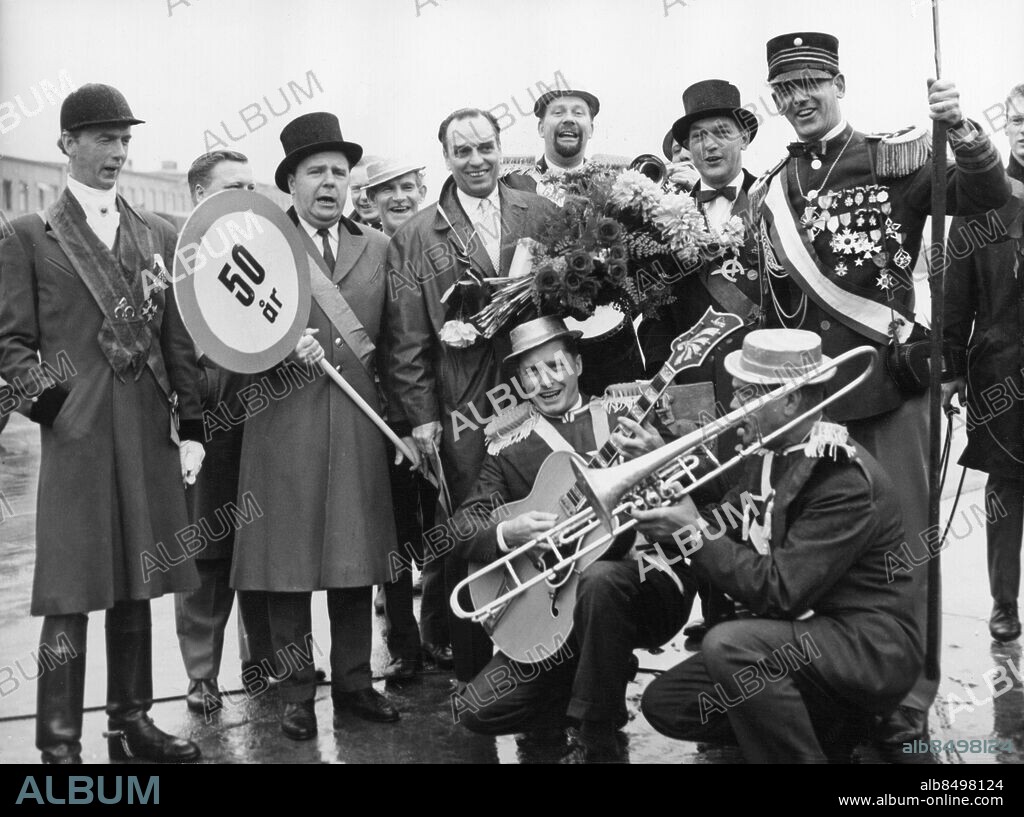 1960-09.. Orig. bildtext... GÖSTA BERNHARD som f.n. gästspelar i Göteborg, passade på måndagen på att fylla 50 år. Eftersom måndagen var spelledig tyckte herr Bernhard att det kunde vara lämpligt att fira födelsedagen hemma i Stockholm och satte sig därför på morgonflyget mot huvudstaden. Ute på Bromma passade vännerna på att ge födelsedagsbarnet en första uppvaktning. Anm. Gratulationer Skyltar CD450 persons: GÖSTA BERNHARD sites: SVERIGE.