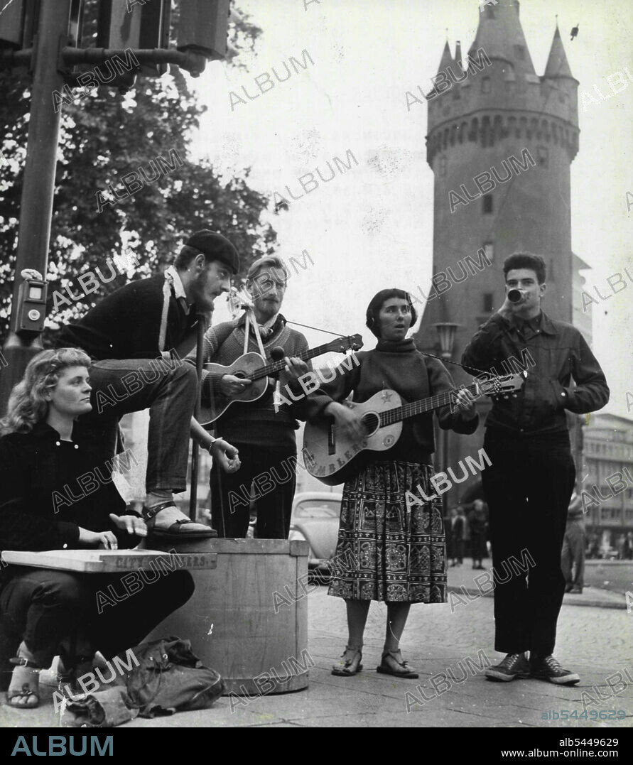 The Happy Wanderers -- The five wandering minstrels give a Jazz Recital by the Eschenheimer Tower in Frankfurt.Five young Londoners are paying their way on a world tour, Much as orchestra of two guitars, one walking stick in a barrel, and a funnel, they are playing their way for pennies across Europe at the moment. October 01, 1955. (Photo by Paul Popper, Paul Popper Ltd.).