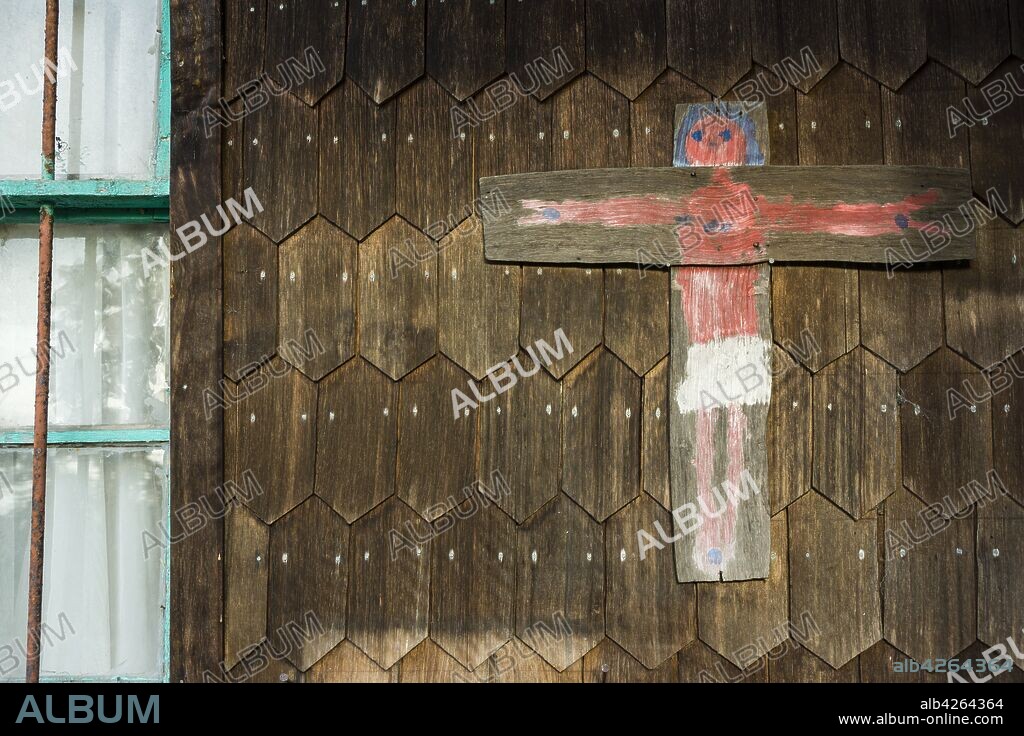 pintura de Jesus crucificado en una vivienda tradicional chilota, fabricada con tejas de madera, Quinchao, archipiélago de Chiloé ,provincia de Chiloé ,región de Los Lagos,Patagonia, República de Chile,América del Sur.