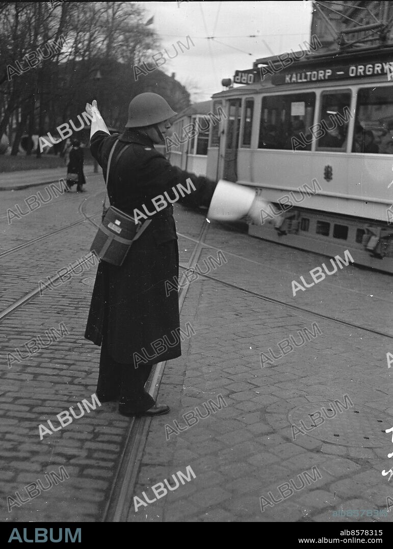 Brunnsparken. Polis med soldathjälm och gasmask dirigerar spårvagns och biltrafiken.. April 1940.. Andra Världskriget. *** Local Caption *** . Kamerareportage.