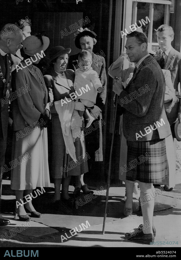 Bonnie Prince Charles Crosses The Border -- Prince Charles makes a grab for his grandfather's stick as his Nurse, Helen Lightbody carries him from Ballater Station. At left is Princess Elizabeth, next to canon W.E. Adams (extreme left) provost of Ballater. (Queen Elizabeth is hidden by the King, others unidentified). Young Prince Charles made a raid across the border between England and Scotland August 6, and captured the hearts of the highlanders who saw him for the first time since his birth nearly a year ago. With his mother, Princess Elizabeth, aunt Princess Margaret and grandparents, King George and Queen Elizabeth, her went by train to Ballater, and from there to Balmoral Castle, where the family will spend a holiday. August 15, 1949. (Photo by Associated Press Photo).