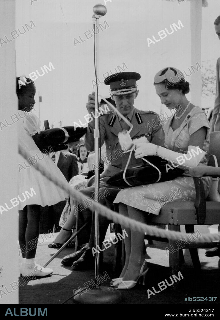 Assisted by the Earl of Ranfurly, Governor of the Bahamas, Princess Margaret opens a gift of a tortoiseshell vanity case. It was presented to her by two little girls on behalf of the people of the Bahamas at a youth rally held on Monday 28th February at Clifford Park, Nassau. February 03, 1955. (Photo by Daily Mirror).