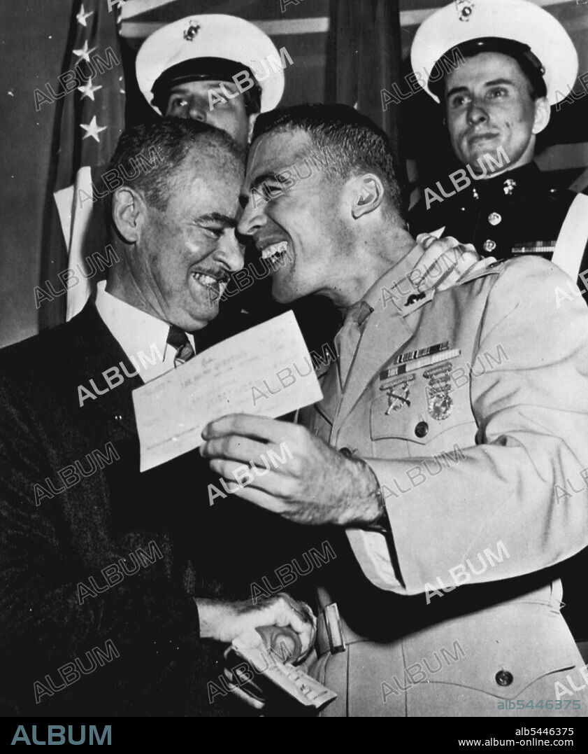 So They Took The $64,000 And -- Marine Capt. Richard McCutchen, and his father and adviser, retired Navy Capt. John C. McCutchen hold check for $64,000-the most fabulous prize in the history of radio and television giveaway shows -- after the young officer knocked off a complicated question about a state dinner at Buckingham Palace. He had previously advanced through stages answering culinary questions until he earned the opportunity to try for the top pay-off. Show was telecast from a Manhattan studio tonight. September 13, 1955. (Photo by AP Wirephoto).