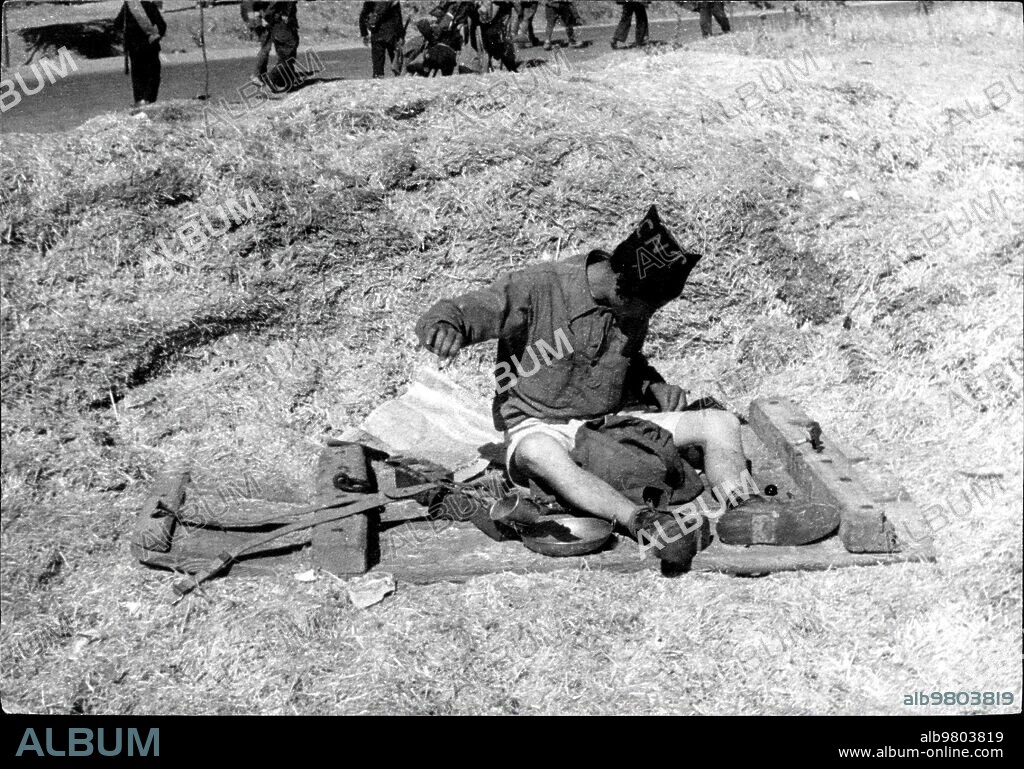 Agosto 1936. Miliciano Cosiéndose su ropa de los Desgarrones Sufridos en la Campaña, en el frente del Tajo.