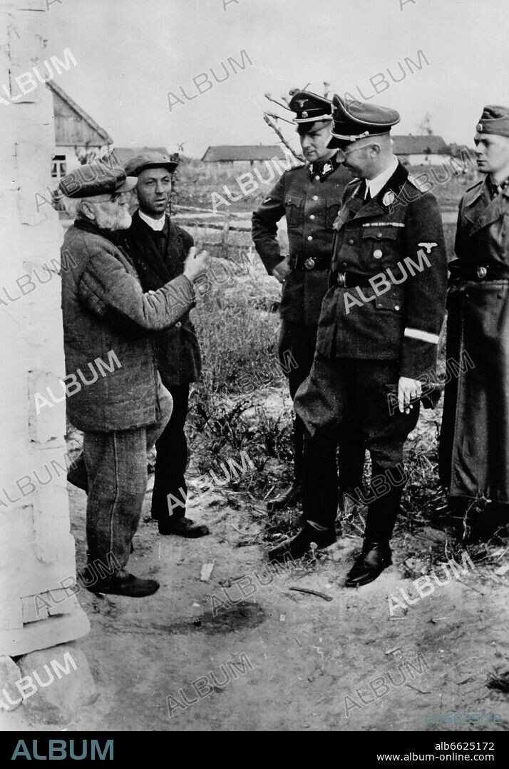 Field Marshal of the SS and Chief of German Police, Heinrich Himmler, talks to locals at the Eastern Front. The Nazi Propaganda! on the back of the image is dated 26 November 1941: "Reichsführer of the SS and Chief of German Police Heinrich Himmler untertook a tour of inspection on the Eastern Front. In a German village in the Soviet area, he stopped and talked intensively with the villagers about their suffering under the gruesome yoke of Bolshevism." Photo: Fotoarchiv für Zeitgeschichte/Archiv. 26/11/1941