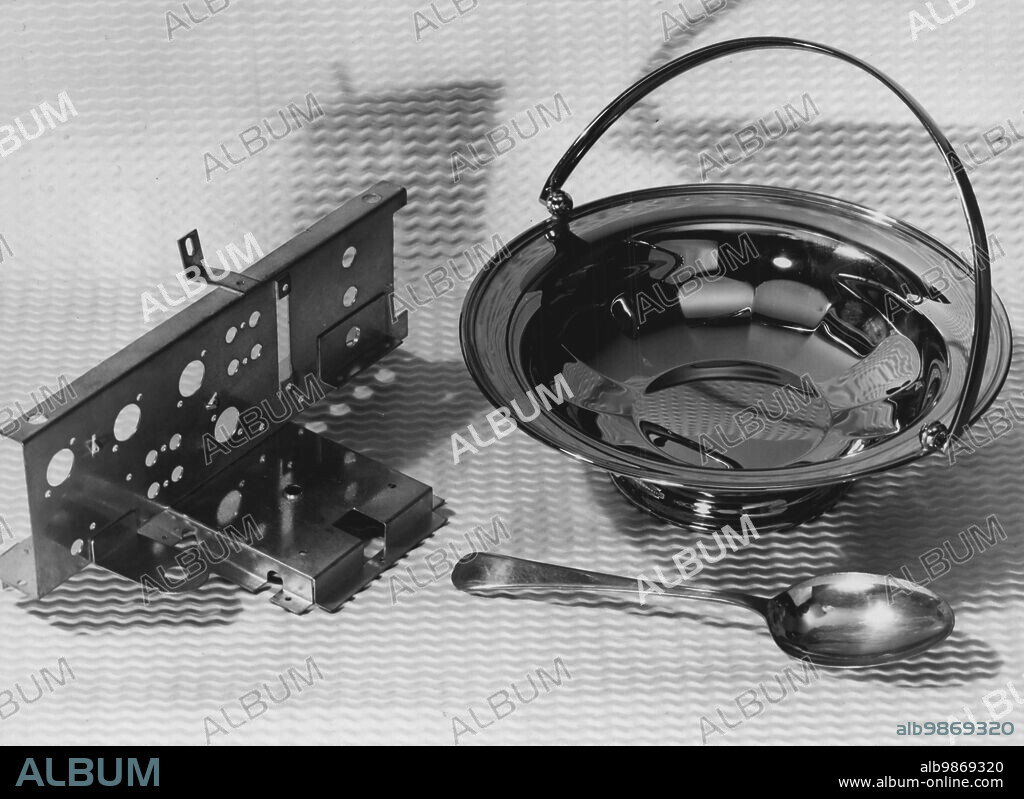 International Research On Use of Tin: Laboratories in Britain Serve The World -- New alloys platings developed by the Tin Research Institute and now in commercial use: Tin-Zine as an anti-corosion coating for radio-chassis. Tin-Nickel plating on a brass fruit-bowl, needs no mechanical polishing after deposition and bas as warmer, pleasanter tone than chromium. Spoon is coated with"Speculum" a tin-copper alloy now available as a  plated coating but used earlier in Greco-Roman times and in Ancient China in the form of cast mirrors hence the name. May 14, 1953. (Photo by Central Office Of Information Photograph).