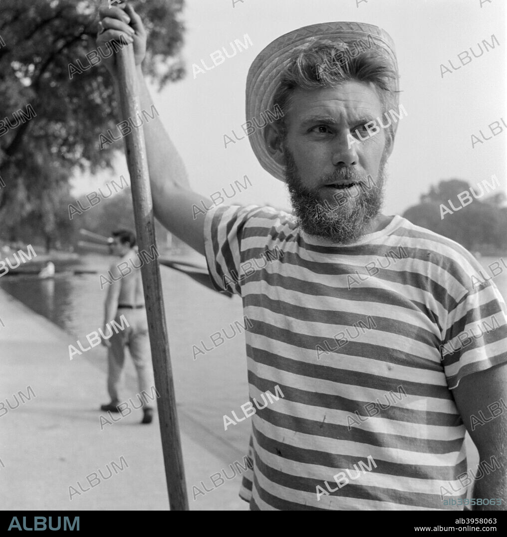 An informal portrait of a boatman wearing a stripey T-shirt and a straw boater, Greater London, c1946-c1959.