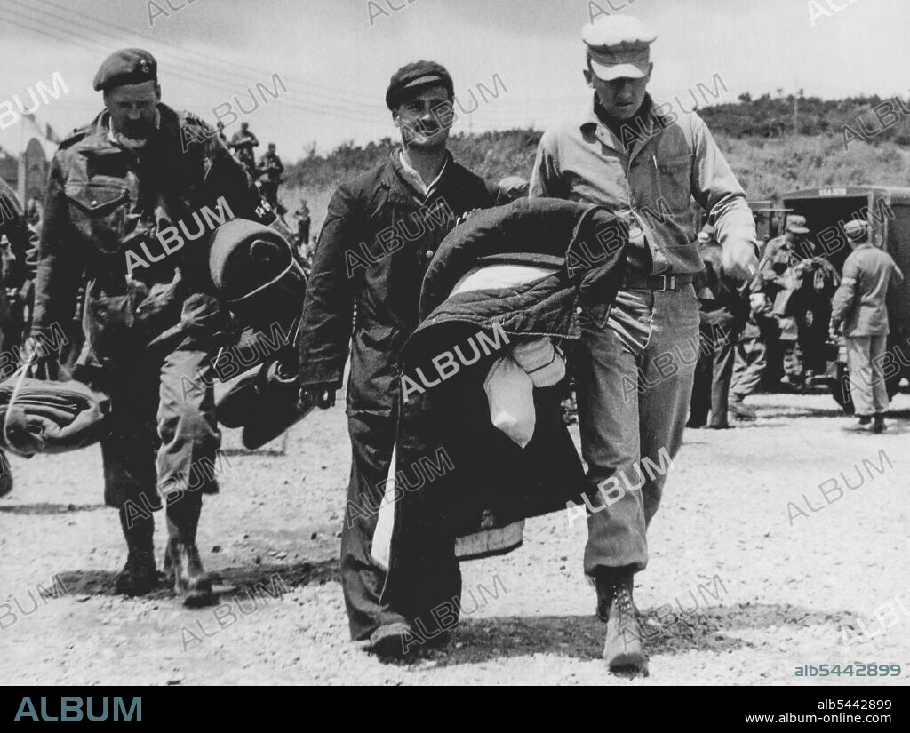 British Commonwealth POW's Arrive At Freedom Village, Korea L/Cpl Robert Guess, still dressed in his blue cotton, Kapok-filled prison garb smiles happily as he approaches Freedom Village, which was specially erected for the reception of returning prisoners of war. A member of the Royal Norfolk Regiment, Pte Guess lives at 17 Pear Tree Road, Stopsley, Luton, Bedfordshire, England. April 21, 1953.
