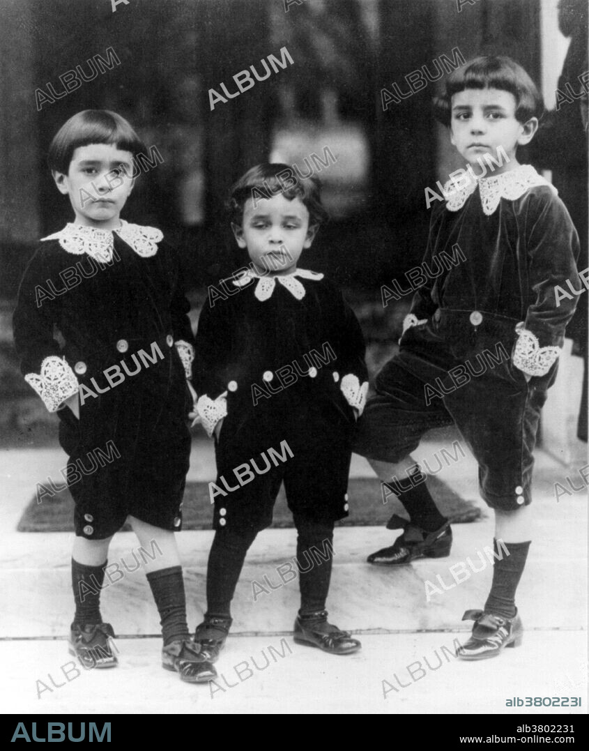 Entitled: "Children wearing velvet suits inspired by Little Lord Fauntleroy style". The classic Fauntleroy suit was a velvet cut-away jacket and matching knee pants worn with a fancy blouse with a large lace or ruffled collar. The Fauntleroy suit, so well-described by Burnett and realized in Reginald Birch's detailed pen-and-ink drawings, created a fad for formal dress for American middle-class children. The Fauntleroy suit appeared in Europe as well, but nowhere was it as popular as in America. They were a major fashion until after the turn of the 20th century. Many boys who did not wear an actual Fauntleroy suit wore suits with Fauntleroy elements such as a fancy blouse or floppy bow. National Photo Company circa 1909-1932.