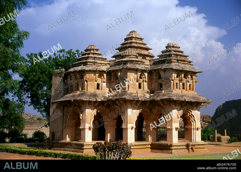 The Lotus Mahal is a construction of the later Vijayanagara period and shows Islamic influence in its arched gateways and vaulted ceilings. The Zenana Enclosure is a walled compound that originally housed the women of the royal household. Hampi is a village in northern Karnataka state. It is located within the ruins of Vijayanagara, the former capital of the Vijayanagara Empire. Predating the city of Vijayanagara, it continues to be an important religious centre, housing the Virupaksha Temple, as well as several other monuments belonging to the old city.