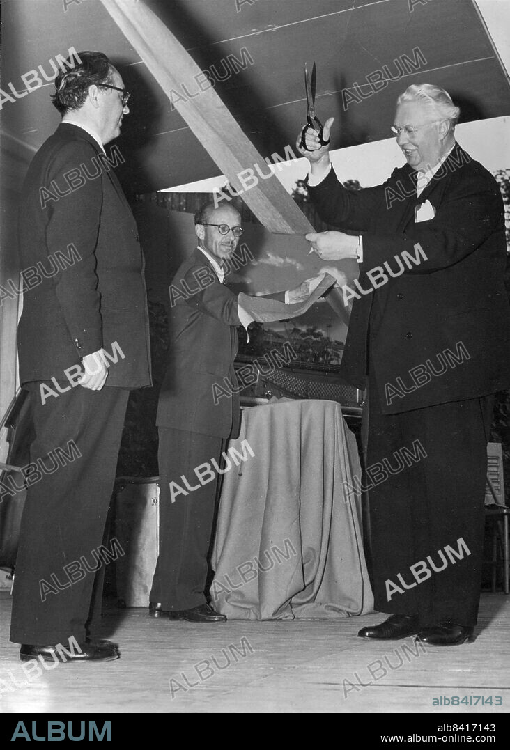 Stockholm 1954-06-14. Vitabergsparken. Kommunfullmäktiges ordförande Carl Albert Anderson (S) klipper av bandet som stadsträdgårdsmästare Holger Blom håller upp, och därmed är Vitabergsteatern invigd. Borgarrådet Helge Berglund står i givvakt och övervakar händelsen. Foto: Roland Jansson / DN / TT / Kod: 29. ** SvD OUT **.