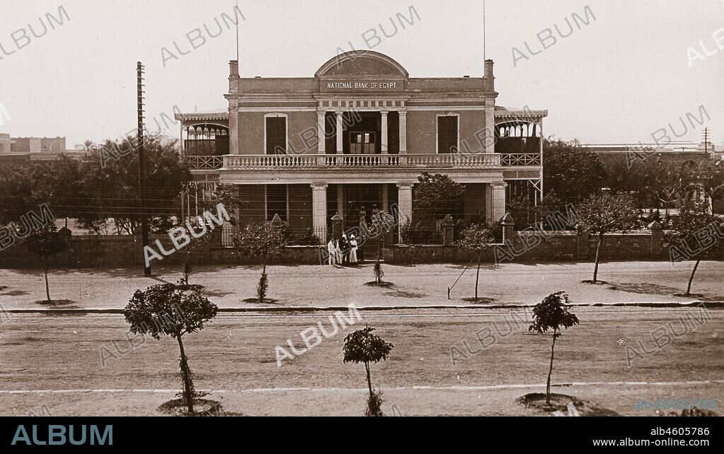 Sudan, Printed caption reads: 'National Bank of Egypt, Khartoum. Published by G N Morhig, The English Pharmacy, Khartoum. Copyright 213'. Exterior view of the façade of the National Bank of Egypt in Khartoum. The two-storey building, built in 1901, features a colonnaded verandah and a walled garden, [c.1906]. 2003/222/1/1/28.