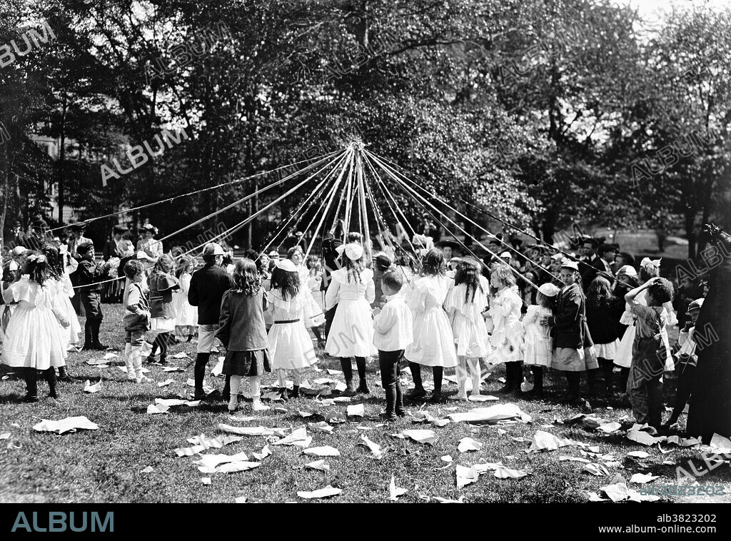Entitled: "May pole dance, Central Park, New York." Maypole dancing is a form of folk dance from Germany, England, and Sweden. The most popular maypole dance consists of dancers that perform circle dances around a tall, garland-festooned pole (originally a live tree).The dancers move in a circle, each holding a colored ribbon attached to a much smaller pole. As they move around the pole, the dancers intertwine their ribbons either in a web around the pole or to plait it to the pole, itself. To unravel the ribbons, the dancers retrace their steps. Historians believe the first maypole dance originated as part of Germanic pagan fertility rituals. While dancers usually perform this dance in the spring on May 1 or May Day, those in Sweden perform it during their midsummer celebrations. Photographed by the Detroit Publishing Company, 1905.