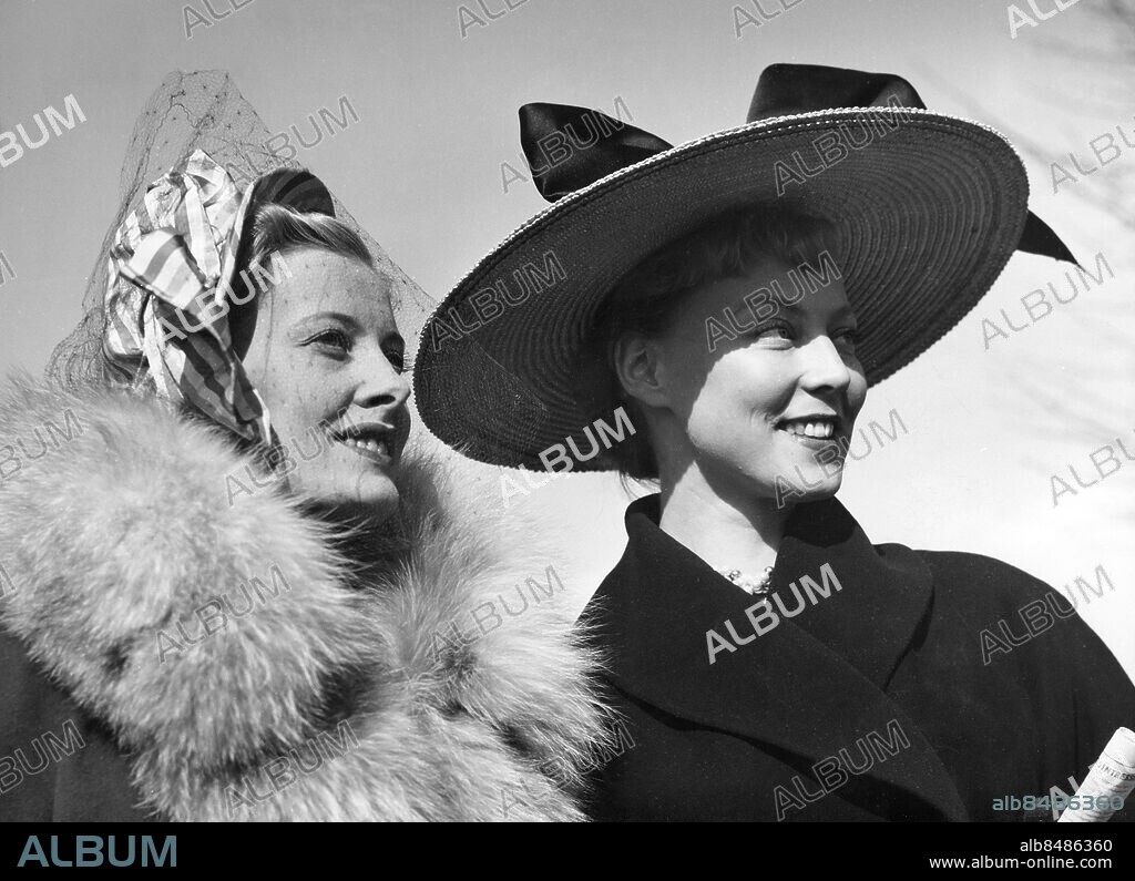SOLNA 1948-04-25.. Inga-Maja Hedelius och Anita Eriksson väcker uppmärksamhet bland publiken med sina vårdräkter och hattar enligt nya modet vid hästkapplöpningspremiären på Ulriksdal. Foto: Text & Bilder / SVT / Kod: 5600. Mapp: Hästsport: Publik på Ulriksdal. Pälskragar.