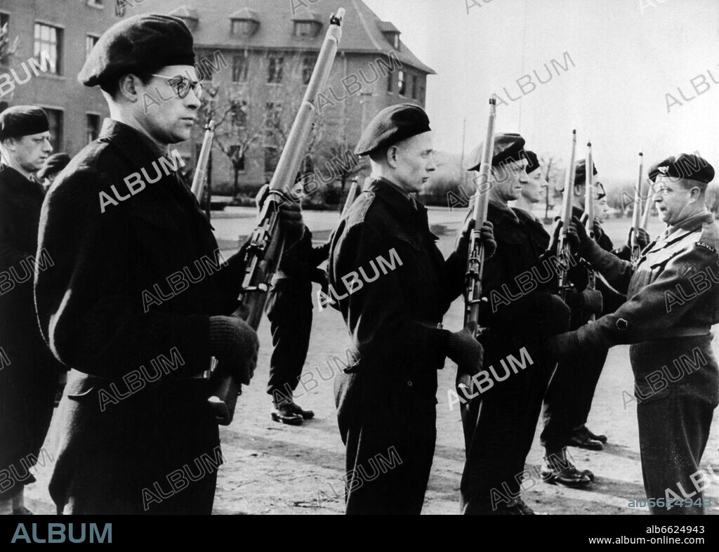 A British instructor showing the handling of the carabiner to members of the German guard service for the British occupation troops in Germany, called Army of the Rhine, on 7th February 1951. 07/02/1951