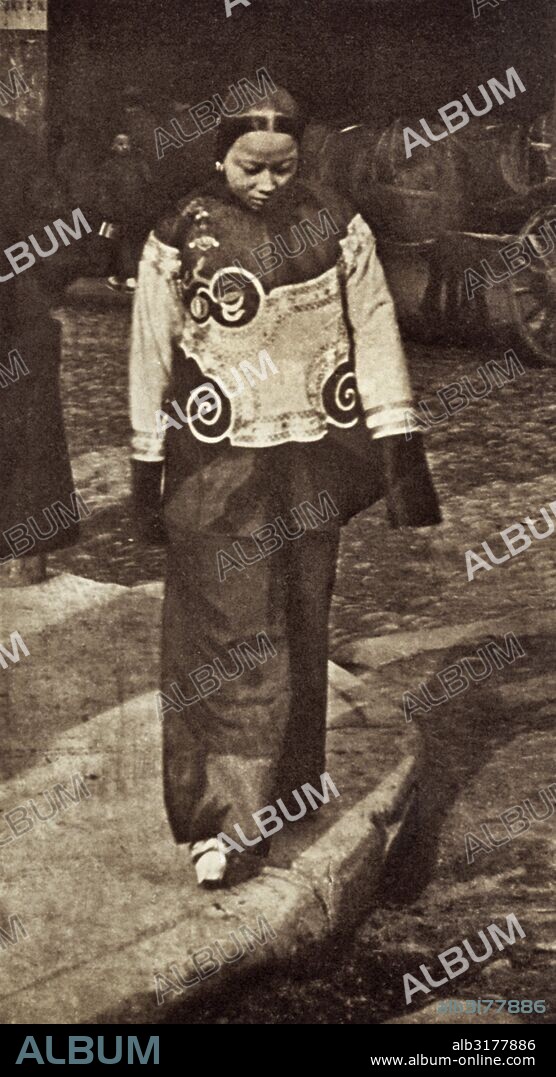 San Francisco, California:   c. 1890 A slave girl in Chinatown wearing holiday attire. From a photograph by Arnold Genthe.   © Underwood Archives / The Image Works.