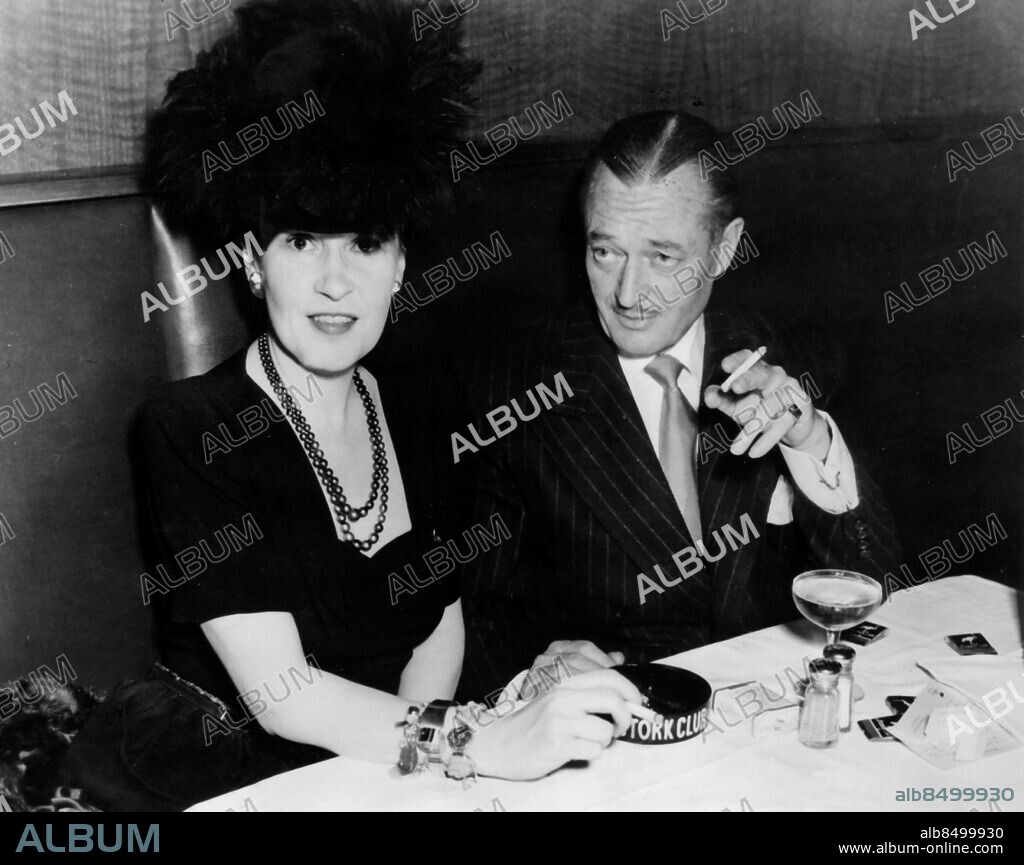 Orig. bildtext... LOWE HEAR THE GENTLE LARK New York. Lady Thelma Vanderbilt Furness is pictured at the Stork Club with stage star Edmund Lowe and as is quite usual when two people of opposite sexes are seen together constantly in night club society, the question arises concerning the matrimonial perspective. Society columnists have already raised the question. 11-21-46 Anm. Thelma, Viscountess Furness, f Morgan, 1904-1970, tvillingsyster till Gloria Morgan Vanderbilt. E Lowe, 1890-1971, amerikansk skådespelare. Armband Drinkar Klackringar Mustascher Pärlhalsband CD641 persons: THELMA MORGAN FURNESS;EDMUND LOWE sites: NEW YORK;USA.