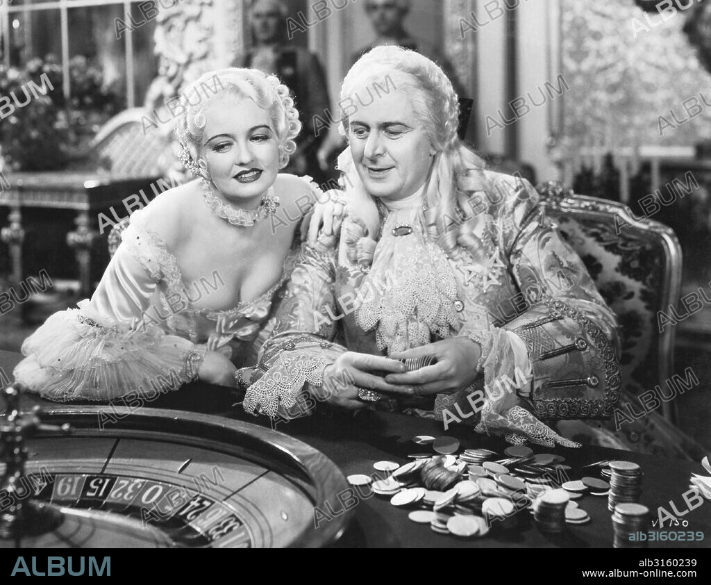 Hollywood, California: 1933 A scene from the movie 'Voltaire', with Doris Kenyon as Mme. Pompadour and Reginald Owen as King Louis XV as he gambles at a roulette wheel.