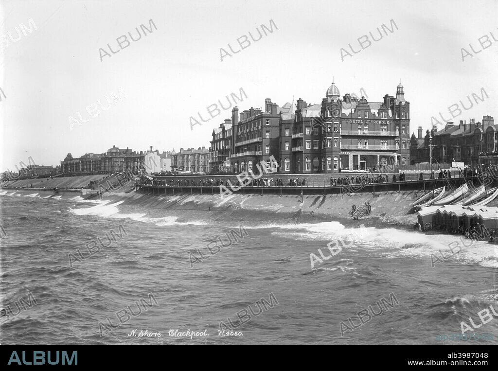 Hotel Metropole, Blackpool, Lancashire, 1890-1910. The north shore at Blackpool with people walking along the promenade by the Victorian Hotel Metropole. Beach huts have been pulled closer to the railings out of the way of the rough sea.