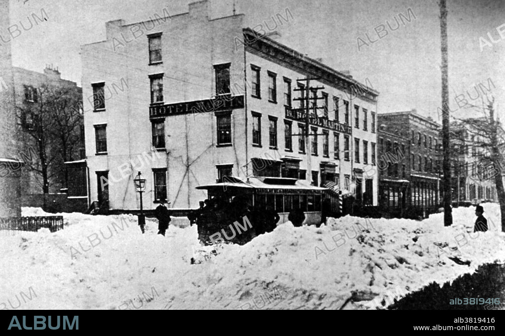 The Great Blizzard of March 12, 1888 is considered to be one of the most famous blizzards in American history on record because it was created by a rare combination of meteorological events. The blizzard of March 11-14, 1888 is often called the "The Great Blizzard of 1888" or the "The White Hurricane." This is the first blizzard to be captured in pictures. Snowfalls of 40-50 inches fell in parts of New Jersey, New York, Massachusetts and Connecticut, and sustained winds of over 45 miles per hour produced snowdrifts in excess of 50 feet. Railroads were shut down and people were confined to their houses for up to a week. Originally captioned: "Hotel Martin, 17-19 University Place, corner of 9th Street during the March 1888 blizzard. Abandoned horse-car.".