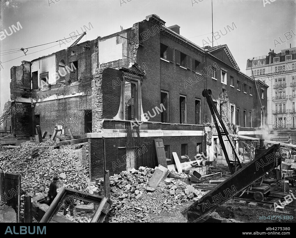 AJ POUND. Devonshire House, Piccadilly, Westminster, London, c1924. Devonshire House viewed from the south-west during demolition with the Berkeley Hotel partially visible in the background. The Palladian house was designed by William Kent for William Cavendish, 3rd Duke of Devonshire, and completed in c1740. The house stood entry after the First World War until its demolition.