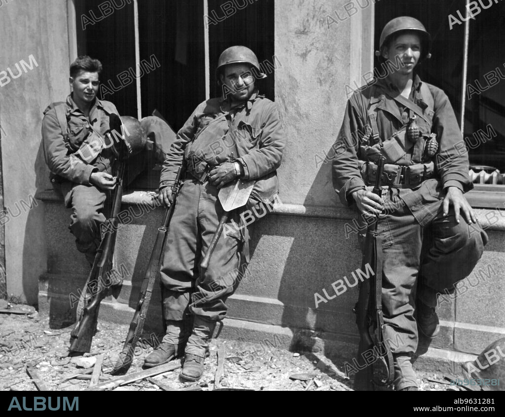 Villedieu, France, August 4, 1944 Pvt Charles E. Frady, Rocky Mount, North Carolina, Asst Sqd LDR Raymond E. Taber, St. Louis, Missouri and PFC John R. Garstrom, Jamestown, New York, take a short break during a Yank infantry drive in the village of Villedieu.
