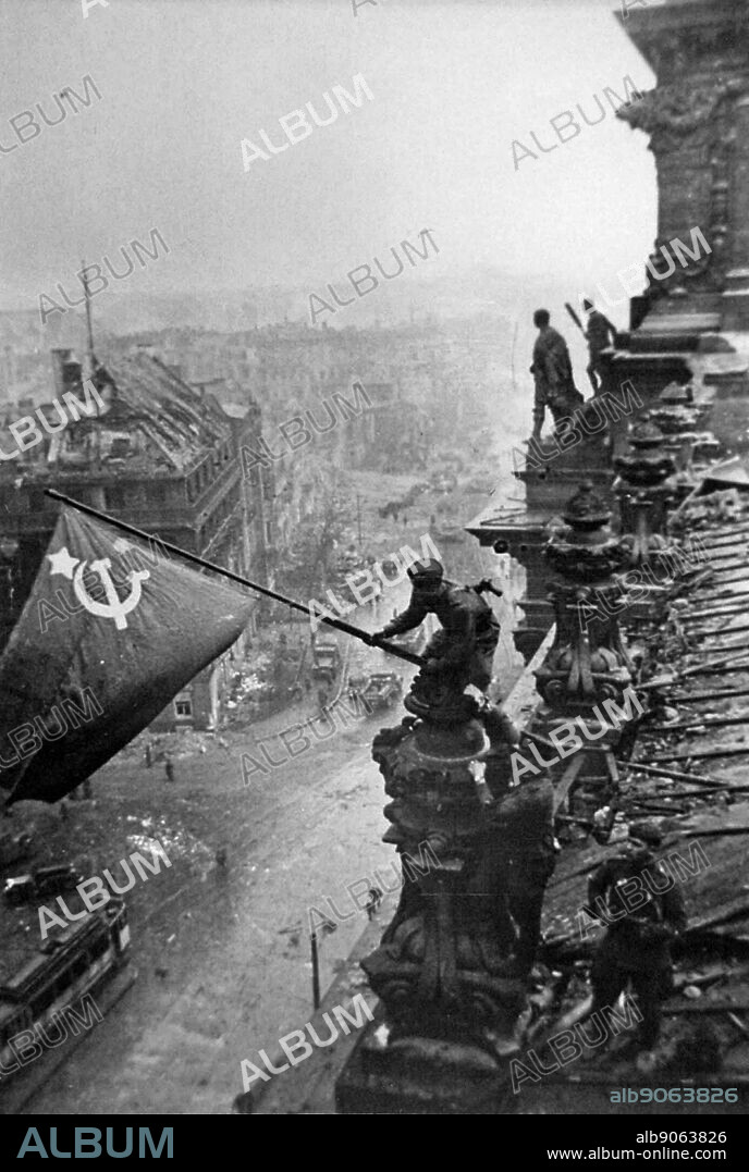 Russian flag is flown over the ruins of the Reichstag, in Berlin at the end of world war two. (photo by Yevgeny Khaldei, 1945).