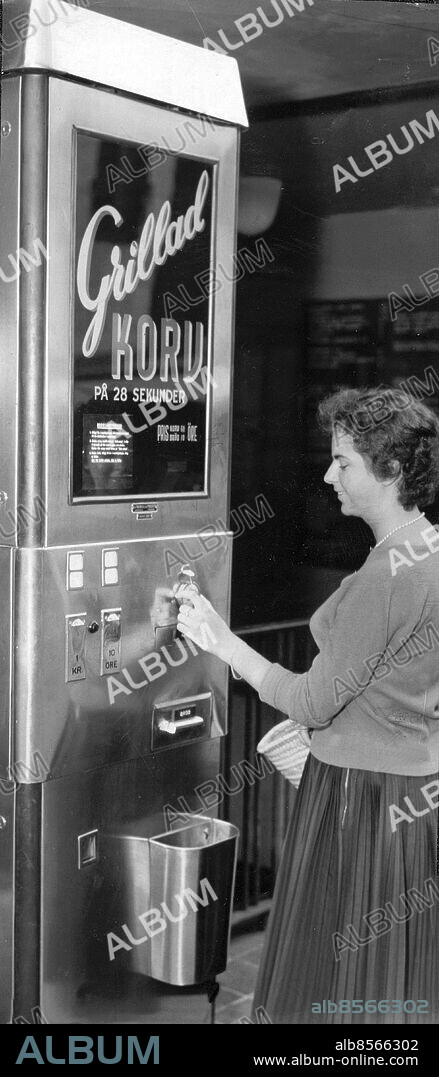 Stockholm 1955-07-22. Grillad korv på 28 sekunder kan ni få ur den här automaten vid trappnedgången från Regeringsgatan till Kungsgatan i Stockholm. Korven kostar 60 öre och brödet 10 öre. När ni ställt in senapsratten på med eller utan får ni ut bröd och korv i två olika fack Sedan är det bara att plocka ihop dem och äta!.. Foto: Lasse Olsson / Expressen / TT / Kod: 45. ** AFTONBLADET OUT **.